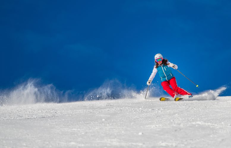 Woman Girl   Female Skier skiing downhill during sunny day i